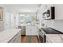 Bright kitchen with white cabinets, stainless steel appliances, subway tile backsplash, and marble countertops at 2111 Isom St, Charlotte, NC 28208