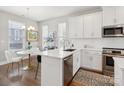 Well-lit kitchen featuring white cabinetry, stainless steel appliances, and a cozy dining area at 2111 Isom St, Charlotte, NC 28208