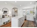 Modern kitchen with white cabinets, stainless steel appliances, island, and hardwood floors at 2111 Isom St, Charlotte, NC 28208