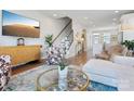 Elegant living room with a modern aesthetic, showcasing chic furniture, a large screen TV and hardwood flooring at 2111 Isom St, Charlotte, NC 28208