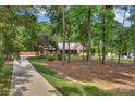 Long driveway leading to a brick home with a welcoming front porch and lush, wooded surroundings at 2202 Bearskin Ln, Monroe, NC 28110