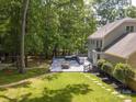 Spacious backyard featuring a large deck with a hot tub and lush green space surrounded by mature trees at 2329 Wedgewood Dr, Matthews, NC 28104