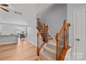 Hallway with wood floors, staircase with wood and iron railing, and views of the kitchen and dining area at 233 E Waterlynn Rd # B, Mooresville, NC 28117