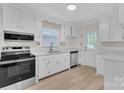 Bright kitchen features white cabinets, stainless steel appliances, and neutral countertop at 3733 Manchester Dr, Charlotte, NC 28217