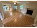 Open living room featuring a brick fireplace and wood flooring at 396 Pitts School Nw Rd, Concord, NC 28027