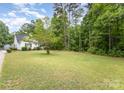 Expansive backyard features a lush green lawn and wooded area, offering privacy and space at 406 Brentwood Cir, Kannapolis, NC 28081