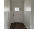 A bright foyer with white walls, wainscoting, a white door with glass panels, and dark wood flooring at 418 W Westview St, Gastonia, NC 28052