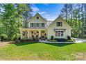 Beautiful exterior of home featuring a covered front porch and lush green lawn and mature trees at 4290 Palm Dr, Denver, NC 28037