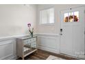 Bright entryway featuring wood floors, an accent table with an orchid, and a front door with a wreath at 4312 Plumeria Way, Fort Mill, SC 29707