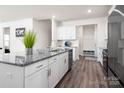 Open kitchen featuring a large island with granite countertops, white cabinets, and stainless steel appliances at 4312 Plumeria Way, Fort Mill, SC 29707
