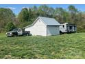 A truck and a camper are parked near a barn, offering space and function at 548 Alspaugh Dam Rd, Taylorsville, NC 28681