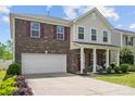 A lovely two-story home with brick and siding, features a well-manicured lawn and concrete driveway at 6041 Laurent Ave, Fort Mill, SC 29715