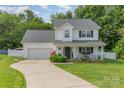 Charming two-story traditional home with inviting front porch and manicured lawn on a landscaped lot at 636 Sadler Glen Dr, Charlotte, NC 28214