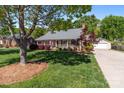 Quaint single-story house featuring a welcoming front porch, mature trees, and a detached two-car garage at 806 Mcgregor Ne Dr, Concord, NC 28025