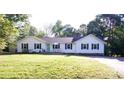 Charming one-story home featuring a well-manicured lawn and a inviting blue front door, creating a welcoming curb appeal at 854 Silver Fox Dr, Concord, NC 28025