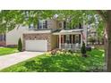 Charming two-story home featuring a brick facade, attached garage, and covered front porch at 1011 Master Gunner Ct, Indian Trail, NC 28079
