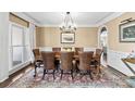 Formal dining room with elegant chandelier, large windows, and classic wainscoting at 107 Waterhouse Ct, Mooresville, NC 28117
