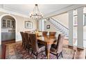 Dining area featuring hardwood floors, an ornate chandelier, and a large dining table with chairs at 107 Waterhouse Ct, Mooresville, NC 28117