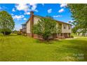 View of backyard with screened-in porch, mature trees, and well-kept lawn at 1260 Summer Ln, Salisbury, NC 28146