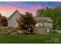 Landscaped backyard with an enclosed porch, mature trees and a lush lawn perfect for outdoor enjoyment at 174 Buffalo Creek Dr, Statesville, NC 28677