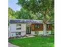 Beautifully updated split level home with mixed siding, black trim windows, and mature shade tree in the front yard at 200 Kimrod Ln, Charlotte, NC 28270