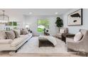 Bright living room with plush white rug, neutral furniture, and a large window offering a view of the outdoors at 200 Kimrod Ln, Charlotte, NC 28270