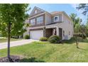 Charming two-story home featuring stone accents, attached garage, and lush green lawn at 2214 Laurens Dr, Concord, NC 28027