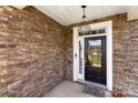 Inviting front door with stone accents, wreath, and a hanging light at 2214 Laurens Dr, Concord, NC 28027