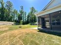 Expansive backyard with a covered porch, stone fireplace, and well-maintained lawn at 2567 Cornelius Nw Pl, Concord, NC 28027