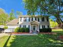 Charming two-story home with manicured landscaping, featuring a covered front porch, neutral siding, and dark shutters at 400 Antlers Ct, Gastonia, NC 28052