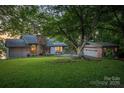 Beautiful home with a stone chimney surrounded by lush greenery and a detached garage at 4749 16Th Street Ne Dr, Hickory, NC 28601