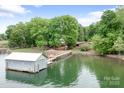 Picturesque lake view featuring a private dock, boathouse, gazebo, and lush greenery at 4798 Lynwood Rd, Sherrills Ford, NC 28673