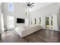 Spacious living room features high ceilings, large windows, hardwood floors, and a comfortable couch at 5028 Lewis Rd, Gastonia, NC 28052
