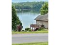 Home featuring a wooden deck overlooking the lake, offering a tranquil outdoor space at 5933 Flintlock Ct, Hickory, NC 28601
