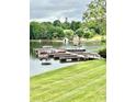 Waterfront home featuring a dock with multiple pontoon boats and scenic views at 5933 Flintlock Ct, Hickory, NC 28601