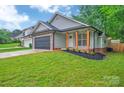 Charming single-story home features a dark garage door and brick accents at 7328 Starvalley Dr, Charlotte, NC 28210