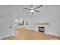 Bright, open living room featuring fireplace, ceiling fan, and view into the kitchen at 7328 Starvalley Dr, Charlotte, NC 28210