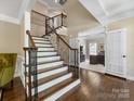 Elegant foyer with a staircase, hardwood floors, and an office space visible in the background at 10716 Meg Meadow Dr, Mint Hill, NC 28227