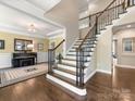 Grand foyer with hardwood floors, staircase, and a piano room featuring a Yamaha piano at 10716 Meg Meadow Dr, Mint Hill, NC 28227