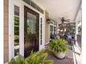 Inviting front porch with a dark wood door, neutral siding, and comfortable seating area at 10716 Meg Meadow Dr, Mint Hill, NC 28227