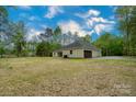 Charming single-story home featuring a spacious yard, attached garage and a private driveway, surrounded by mature trees at 108 Woodwinds St, Locust, NC 28097