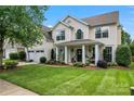 Charming two-story home featuring a manicured lawn and inviting front porch with classic columns at 125 N Wendover Trce, Mooresville, NC 28117