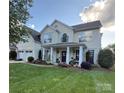 Charming two-story home with a beautifully landscaped front yard and welcoming front porch with columns at 125 N Wendover Trce, Mooresville, NC 28117