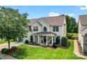Beautiful two-story home with lush lawn, mature trees, and inviting front porch with decorative columns at 125 N Wendover Trce, Mooresville, NC 28117