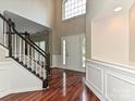 Bright, two-story foyer with hardwood floors, white wainscoting, and view of the front door and staircase at 13237 Fremington Rd, Huntersville, NC 28078