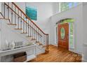 Grand foyer featuring a wooden staircase, hardwood floors, and decorative front door at 202 Whitmyre Ct, Fort Mill, SC 29715