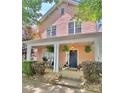 Charming pink two-story home with a inviting front porch, ferns, and meticulous landscaping at 240 Faust Rd, Davidson, NC 28036