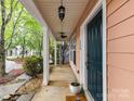 Inviting front porch with white columns, a ceiling fan, and a neatly landscaped entryway at 240 Faust Rd, Davidson, NC 28036