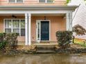 Inviting front porch with white columns, a ceiling fan, and a neatly landscaped entryway at 240 Faust Rd, Davidson, NC 28036