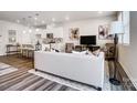 Open-concept living room with modern decor, neutral tones, and seamless flow to the adjacent kitchen at 2415 Hedgecliff Rd, Kannapolis, NC 28025